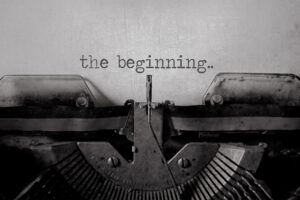 A black and white type writer typing 'the beginning'