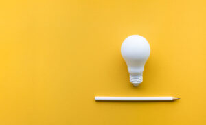 A white light bulb against a yellow background