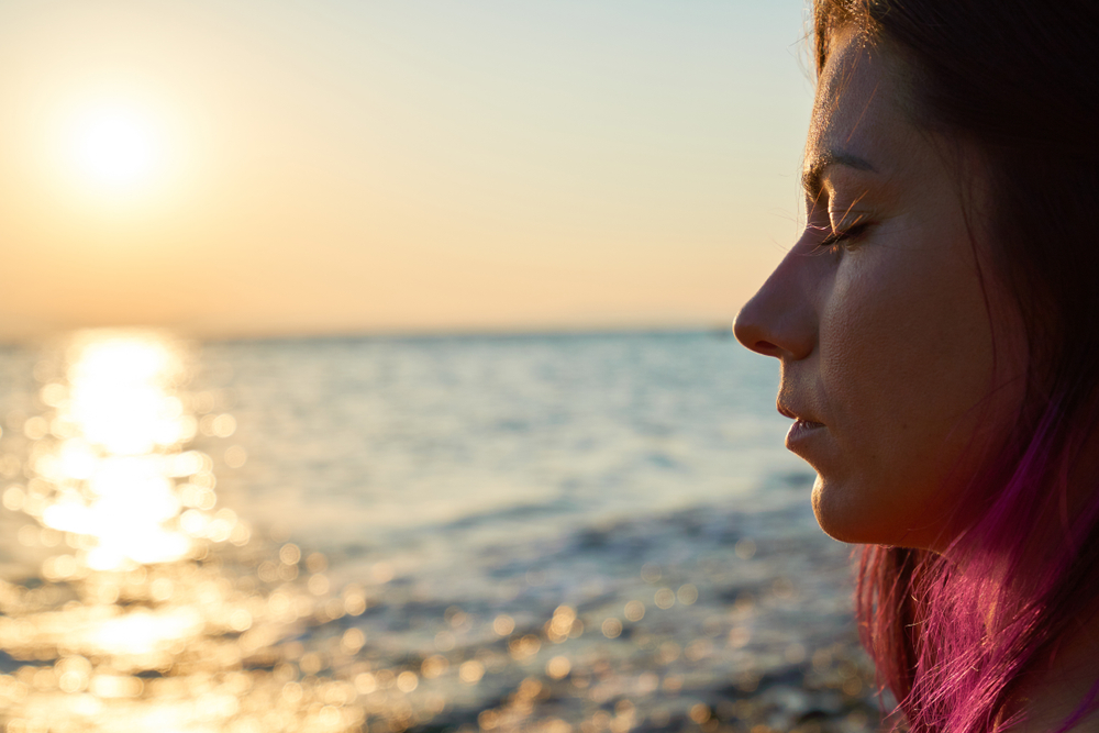 Mindfullness, women meditating, eyes closed, ocean background